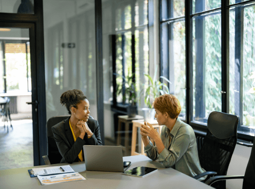 women having a chat at a desk