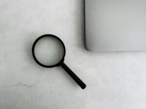 magnifying glass next to laptop