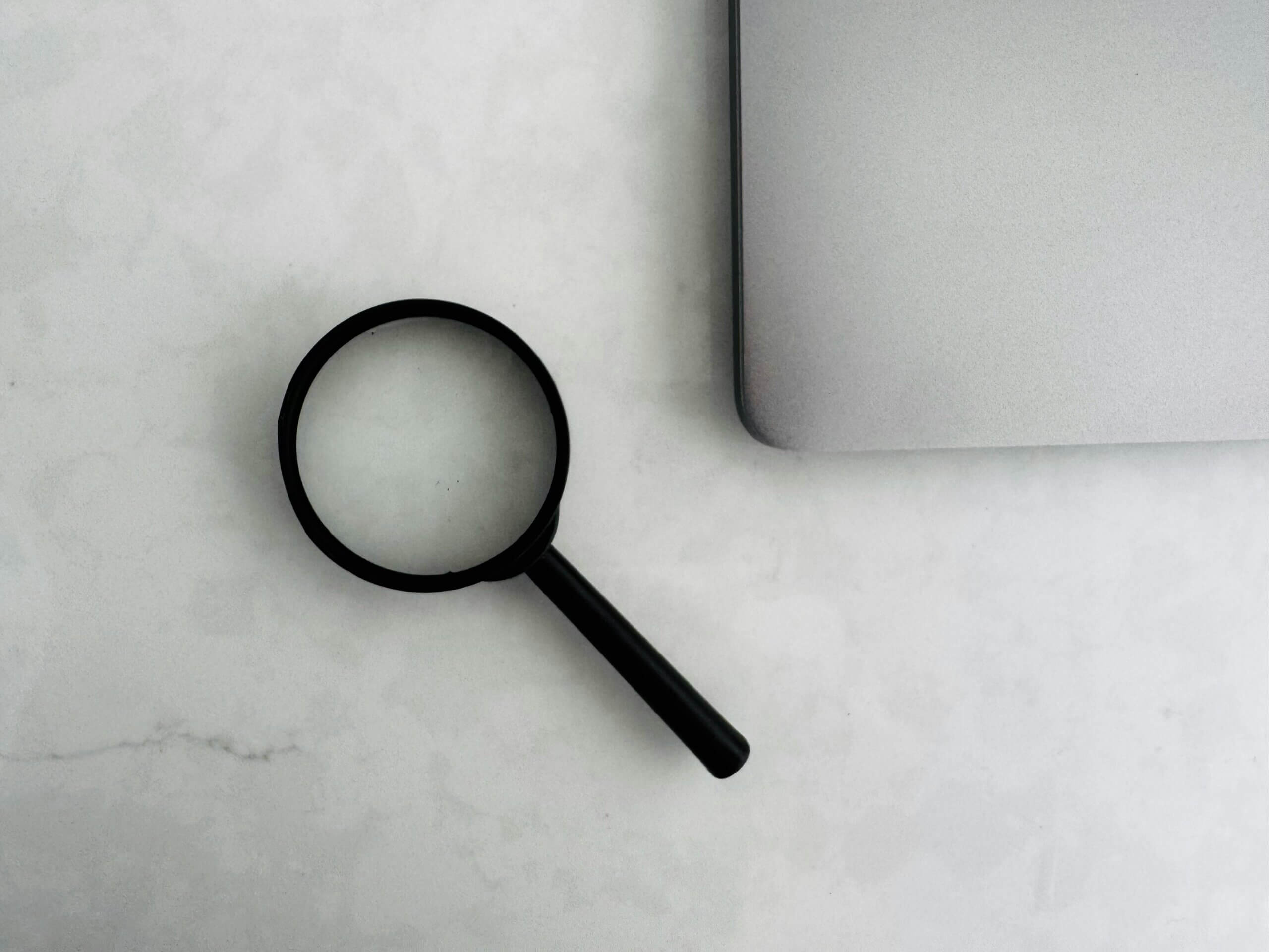 magnifying glass next to laptop
