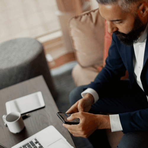 Businessman using cell phone in airport lounge