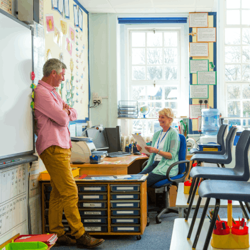 Two teachers meeting in a classroom discussion K-12 buying trends